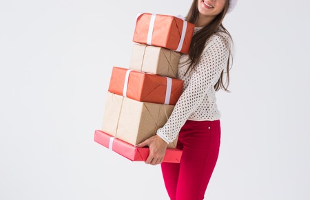 Christmas, holidays and presents concept - Close up of woman holding a lot of gifts on white background with copy spaceの写真素材