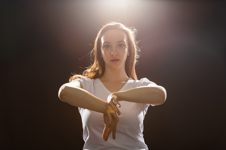 Young woman jazz funk dancer exercising dance moves in studioの写真素材