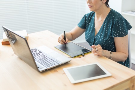Illustrator, web designer and artist concept - Graphic designer using her pen tablet in a bright officeの写真素材