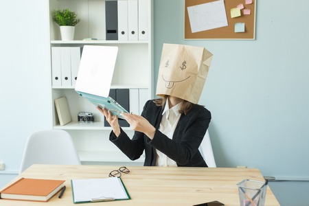 Business, emotions and money concept - office crazy woman put a package with painted funny face on her head. Dollar sign in her eyesの写真素材