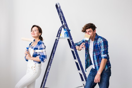 Teamwork, renovation and repair concept - Portrait of funny couple doing redecoration in apartmentの写真素材