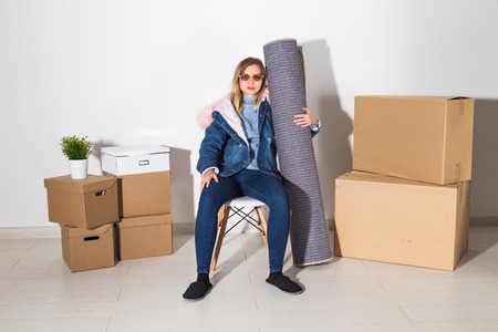 Relocation, new home and real estate concept - Young woman upacking in new flatの写真素材