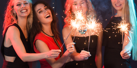 Celebrating with fun. Group of cheerful young women carrying sparklers. New year, holidays and party concept.の写真素材