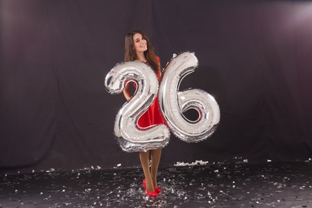 Happy birthday concept - Beautiful young woman with number-shaped 26 balloonsの写真素材