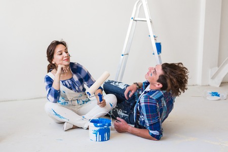 People, repair and relationship concept - Young funny couple doing renovation in new apartmentの写真素材