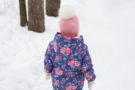 Children and nature concept - Adorable baby girl walking in winter parkの写真素材