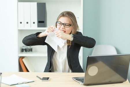 Stress, office, hysteric, people concept - aggressive woman with a lot of work in officeの写真素材