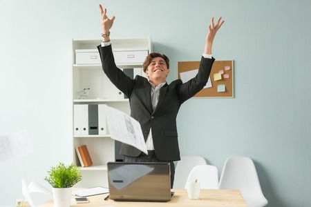 Business people, joke and fun concept - happy funny businessman throwing papers in officeの写真素材
