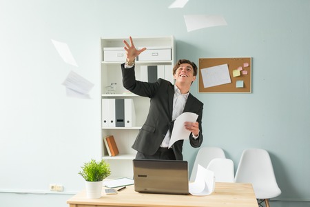 Business people, joke and fun concept - young handsome man in suit having fun in the officeの写真素材