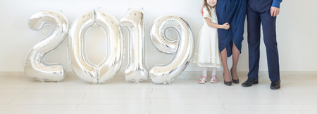 New 2019 Year is coming concept - Close up family standing near silver colored numbers indoors.