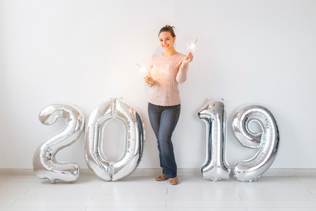 Party, people and new year holidays concept - woman celebrating new years eve 2019 with and sparklersの写真素材