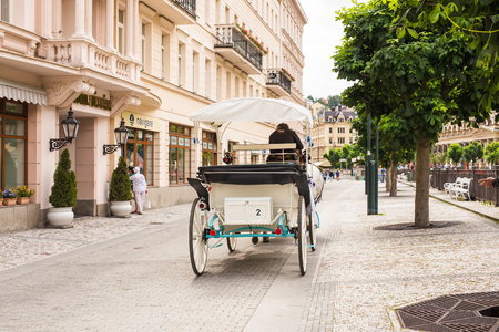 KARLOVY VARY, CZECH REPUBLIC - JUNE 13, 2017: A horse-drawn carriage awaits tourists on the embankment of the Tepla river.のeditorial素材