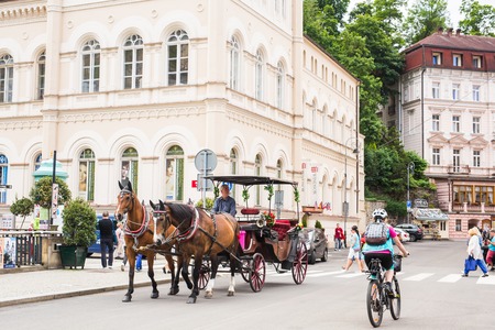KARLOVY VARY, CZECH REPUBLIC - JUNE 13, 2017: A horse-drawn carriage awaits tourists on the embankment of the Tepla river.のeditorial素材
