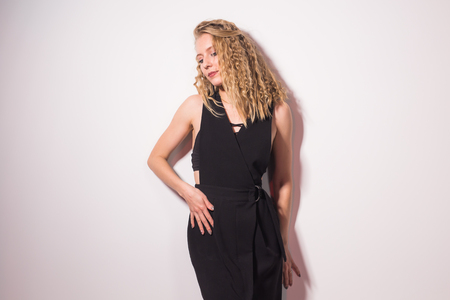 People and fashion concept - Sexy beautiful blond lady model in black dress standing on white backgroundの写真素材