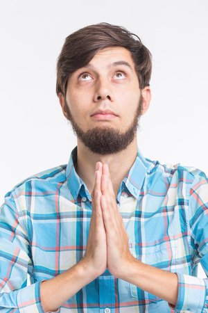 Closeup portrait young man praying, imploring, hands clasped hoping for best asking forgiveness, miracle isolated white backgroundの写真素材