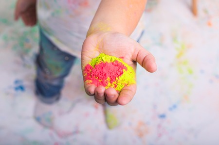 Festival of holi and holidays concept - babys hand with colored powder.の写真素材
