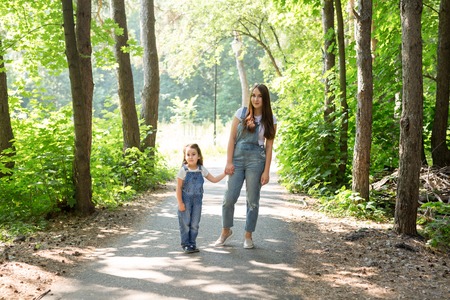 Family, nature and people concept - Mother and daughter spend time together on a walk in the forestの写真素材