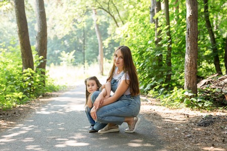 Family, nature and people concept - Mom and little daughter spend time together on a walk in the forestの写真素材
