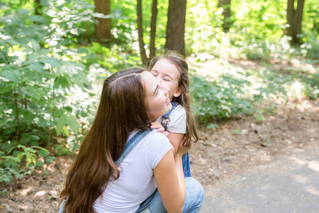 Family, nature and people concept - mother and cute little daughter hugging in the summer parkの写真素材