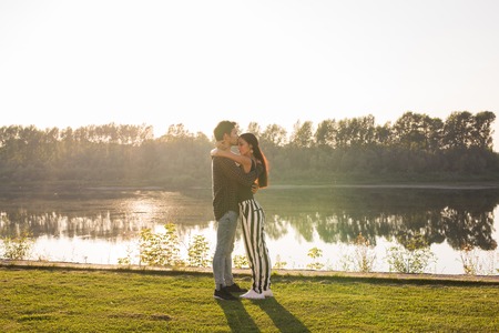 Tenderness, love and nature concept - Beautiful woman and handsome man hugging over water backgroundの写真素材