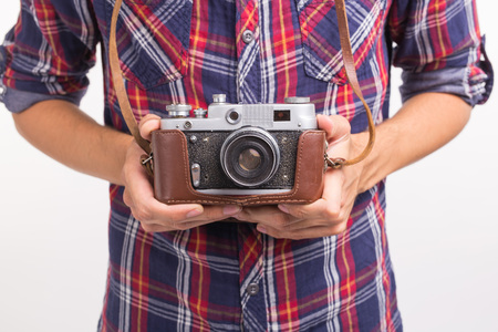Vintage, photographer and hobby concept - close up of retro camera in mans hands over the white...