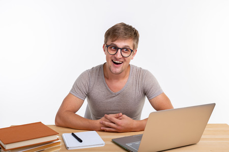 Study, education and emotions concept - male student doing exercises in laptop. He is happy