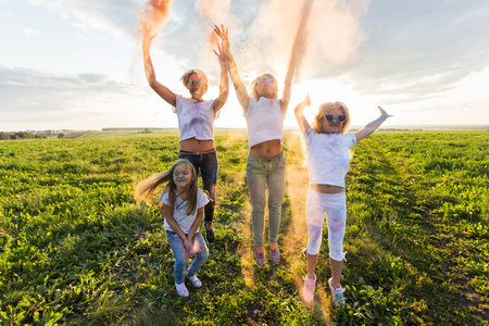 Fun, colors, Indian holidays and people concept - young female people having fun on the festival of holiの写真素材