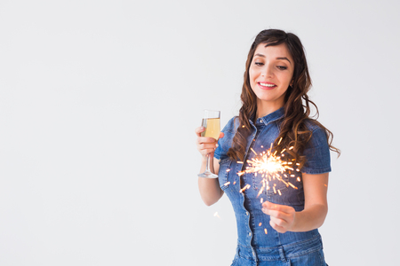 People, celebration and holiday concept - Lovely woman with sparkler and glass of champagne over white background with copy spaceの写真素材