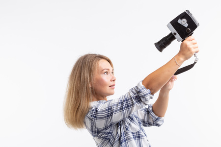 Technologies, photographing and people concept - blonde young woman with retro camera smiling over...