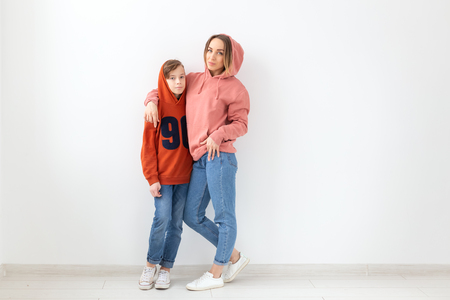 Mothers day, children and family concept - Mother and son dressed in sweatshirts over white background with copy spaceの写真素材