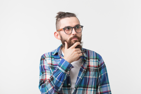 Emotions and people concept - Bearded hipster man thinking about something on white background.の写真素材