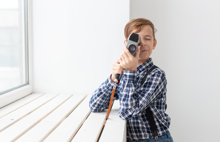photographer, children and hobby concept - cute teen boy posing with retro camera on white backgroundの写真素材