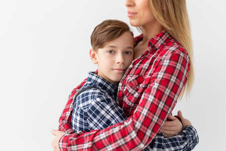 Mothers day, children and family concept - teen boy hugging his mom on white backgroundの写真素材