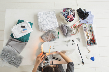 Tailor, fashion and seamstress concept - young female fashion designer in her showroom, top viewの写真素材