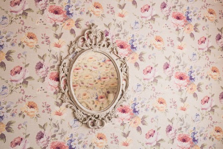 Ornamental frame with mirror inside hanging on wallの写真素材