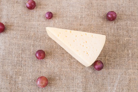 Piece of homemade cheese and grapes, top viewの写真素材