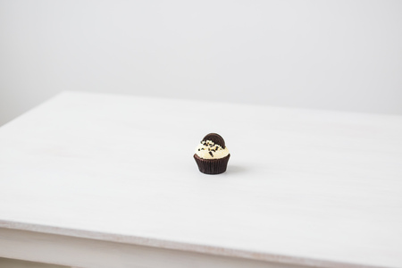 Food, holidays, happy birthday, bakery and desserts concept - delicious cupcake on white table.の写真素材