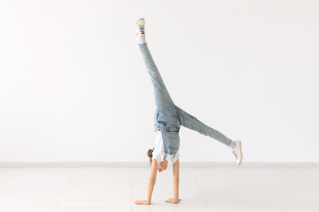 people, sport and children concept - pretty little girl doing gymnastics over white backgroundの写真素材
