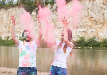 Festival holi, holidays, tourism and nature concept - Portrait of woman and man covered...