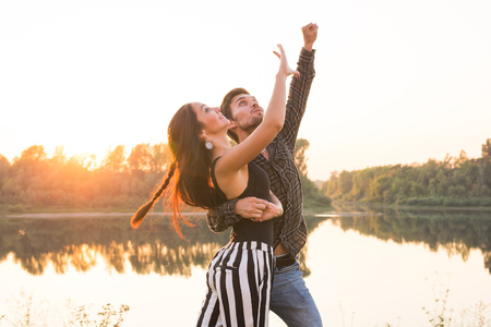 Romantic, social dance and people concept - young couple dancing a tango or bachata near the lakeの写真素材