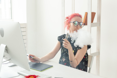 Creative, graphic designer, people concept - young creative woman smoking a vape while working in a graphic tabletの写真素材