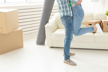 Unidentified young couple in denim pants embracing rejoicing in their new apartment during the move. The concept of housewarming and credit for new housing.の写真素材