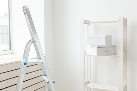 Stepladder and an empty shelf with boxes are in the new living room during the renovation after the move. The concept of housewarming and repair in new housing.の写真素材