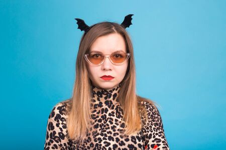 The evil woman with a waist bat on the head. Fancy dress for Halloween on blue background