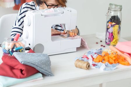 clothing designer, seamstress, people concept - woman seamstress working in her studioの写真素材