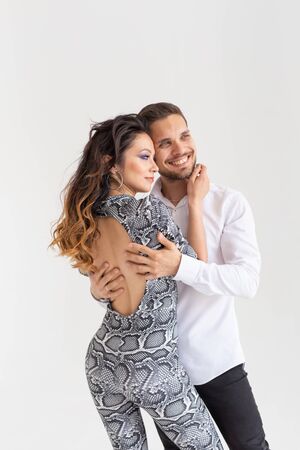 Skillful dancers performing in the white background with copy space. Sensual couple performing an...