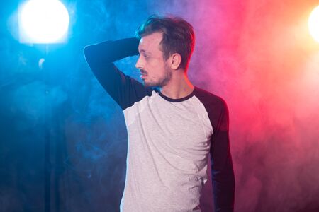 Slim young bearded hipster man in casual clothes posing on a red blue background. Concept of style and confidence.の写真素材
