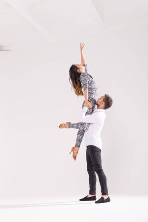 Social dance concept - Active happy adults dancing bachata or salsa together over white background with copy spaceの写真素材