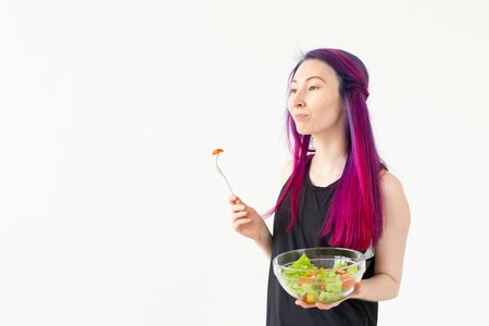 Young fitness girl holding vegetable salad. Concept of sports lifestyle and proper nutrition.の写真素材