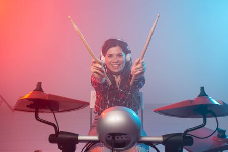Hobby, music and people concept - Excited woman playing the electronic drum setの写真素材